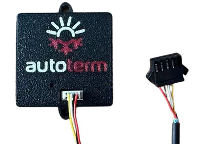 The Autoterm interface module - a small square black case with the autoterm logo on the front and a white connector on one edge, shown beside the plug and flying lead that join it to the heater