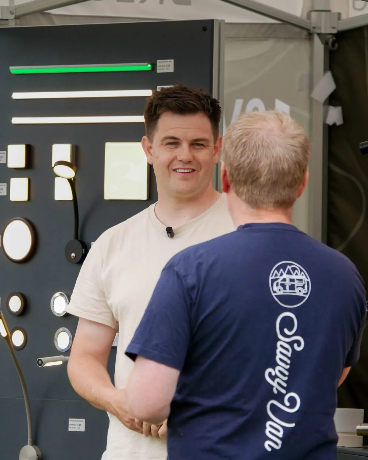 A Bright Vans lighting display board, with one of the Bright Vans team talking to one of the SavvyVan team