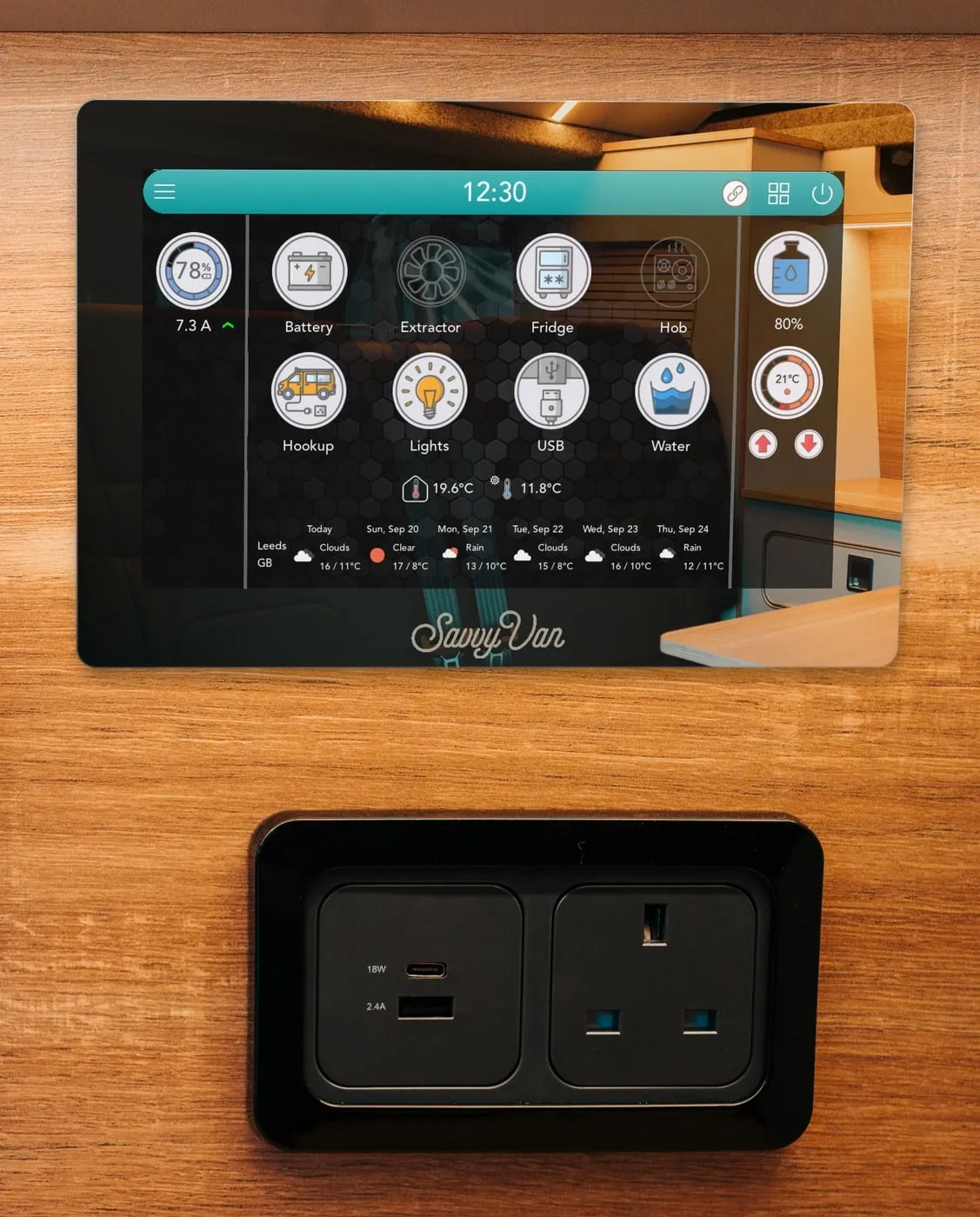 The same mirror switched on: the SavvyVan3 home screen shows through it - the battery at 78%, eight tiles from Battery to Water, the water tank at 80%, the heater at 21°C and the week's weather