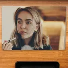 The mirrored SavvyVan3 screen switched off on a wood-panelled van wall, working as a mirror for a woman putting on her make-up
