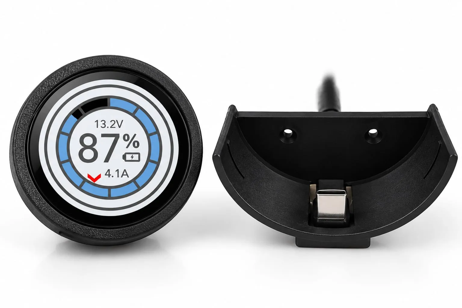 A SavvyDot beside its empty charging plate. The dot's round screen shows the van's battery at 87%, 13.2V and 4.1A; the plate is a curved black cradle with two screw holes and a USB-C contact at the bottom