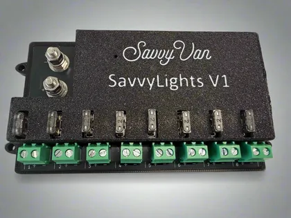 The SavvyLights driver - a black module with eight fused output channels along the front edge and two heavy supply terminals on top