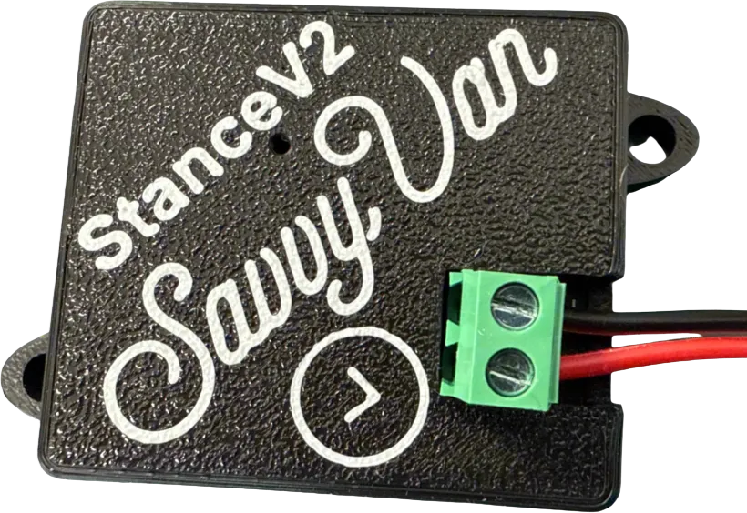 The SavvyStance V2 sensor - a small black module about the size of a matchbox, with mounting lugs at two corners and a green screw terminal carrying its red and black power leads