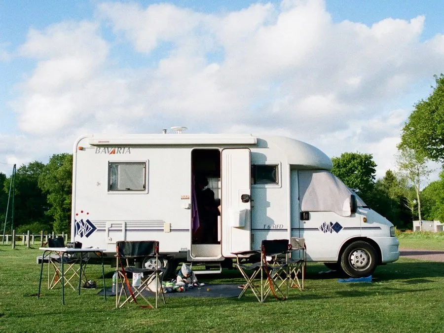 A coachbuilt motorhome parked on grass with its awning out