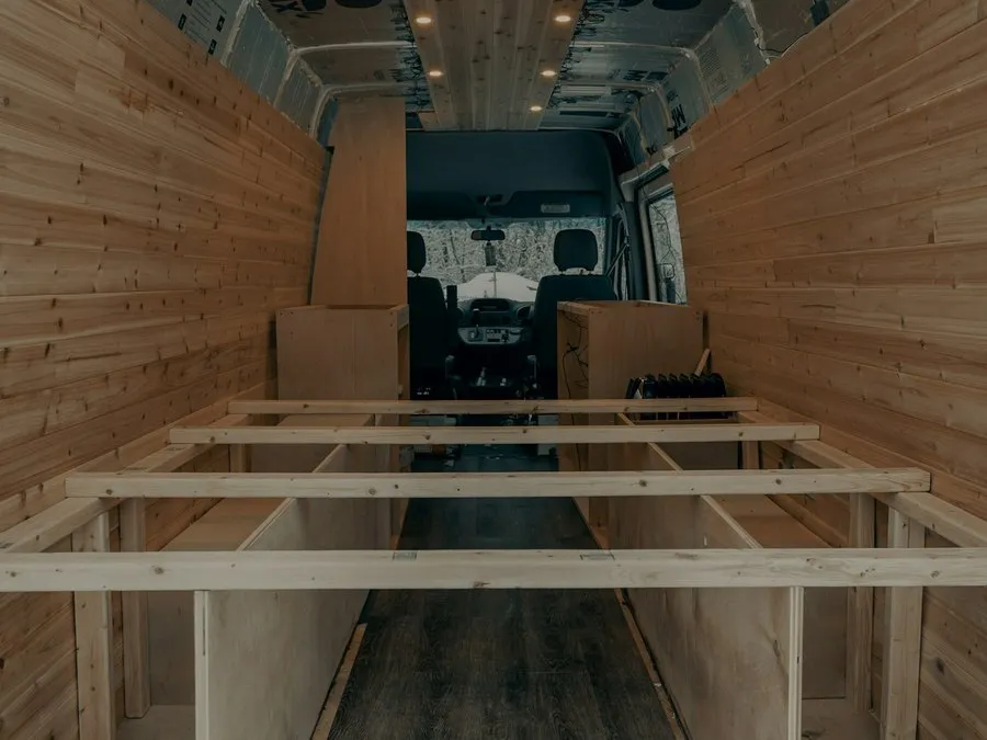 The inside of a van part way through a conversion, with timber floor battens down